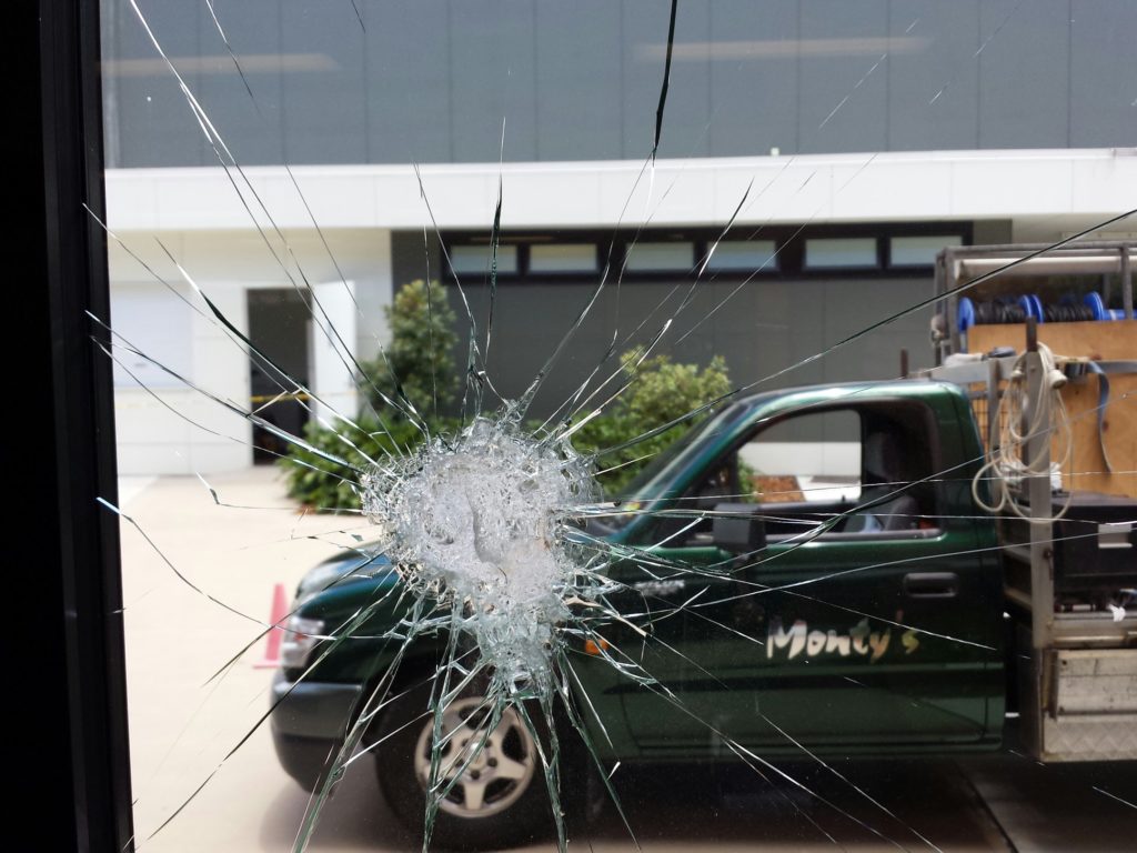 Picture of smashed glass with ute in the background facing left